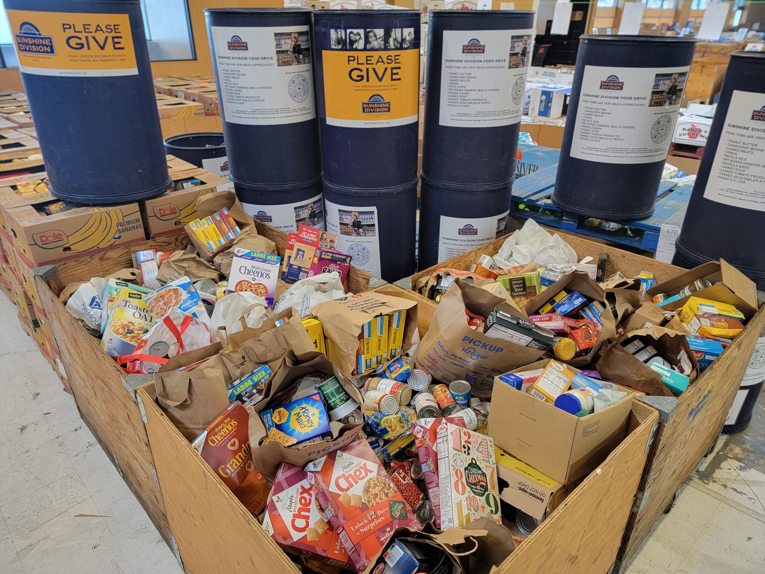 Canned and non-perishable food items in boxes and donation tubs